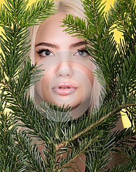 Beauty portrait of beautiful young woman in the branches of a spurce