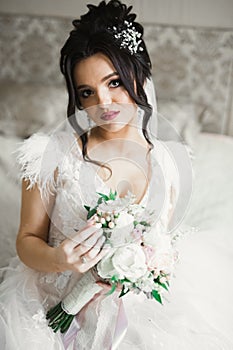 Beauty portrait of bride wearing fashion wedding dress with feathers with luxury delight make-up and hairstyle