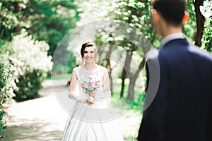 Beauty portrait of bride wearing fashion wedding dress with feathers with luxury delight make-up and hairstyle