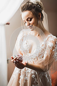 Beauty portrait of bride wearing fashion wedding dress with feathers with luxury delight make-up and hairstyle