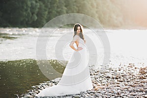 Beauty portrait of bride wearing fashion wedding dress with feathers with luxury delight make-up and hairstyle