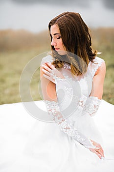 Beauty portrait of bride wearing fashion wedding dress with feathers with luxury delight make-up and hairstyle