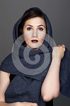 Beauty portrait of brunette woman dressed in dark blue scarf