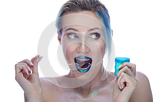 Beauty Portrait of Caucasian Female with Blue Lips and Smooth Skin Wearing Teeth Brackets. Having Fun With Interdental Floss.