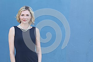 Beauty portrait of elegant blonde lady with casual hairstyle and perfect evening makeup. Woman wearing pearls. Studio shot