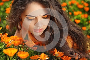 Beauty portrait. Eye Makeup. Beauty Girl over marigold flowers f