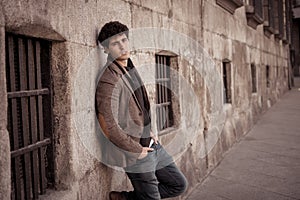 Beauty portrait of fashion young attractive young man posing in urban european city street