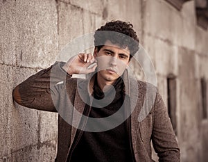Beauty portrait of fashion young attractive young man posing in urban european city street