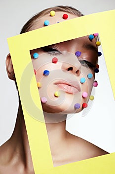 Beauty portrait of girl with colorful balls on her face