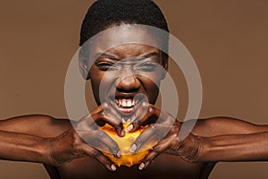 Beauty portrait of half-naked african woman holding kiwano horned melon