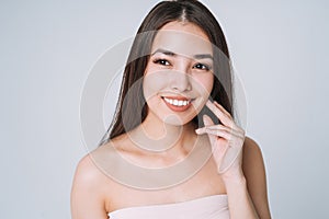 Beauty portrait of happy young beautiful asian woman with healthy dark long hair in top bando on white background isolated photo