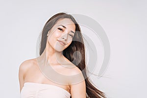 Beauty portrait of happy young beautiful asian woman with healthy dark long hair in top bando on white background isolated photo