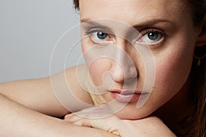 Beauty portrait of a happy young topless woman with natural makeup over white background. Cosmetology and Advertisement