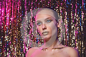 Beauty portrait of a High Fashion model woman in colorful bright neon lights posing in studio, night club On colourful