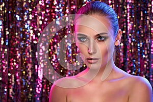 Beauty portrait of a High Fashion model woman in colorful bright neon lights posing in studio, night club On colourful