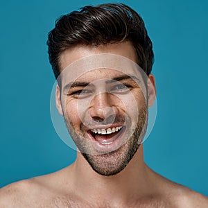 Beauty portrait of joyful naked brunette man with fresh smooth skin and perfect smile looking at camera, posing isolated