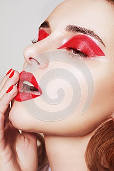 Beauty portrait of sexy women with glamour make up. Red lips and red eyeshadows, neils. Beauty fashion model face. Manicured hand