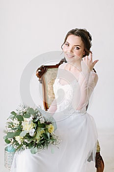 Beauty portrait of smiling bride wearing fashion wedding dress with luxury delight make-up and hairstyle, studio indoor