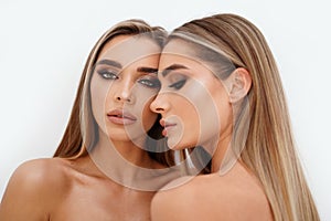 Beauty portrait of two beautiful young women with glowing glamour makeup and long straight hair. Aesthetic medicine concept