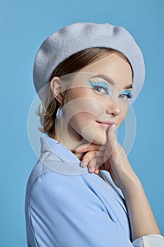 Beauty portrait of a woman with blue eyes, a blue dress and a blue background. Art makeup Professional makeup and cosmetics for