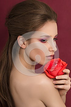 Beauty portrait of young brunette woman holding red rose