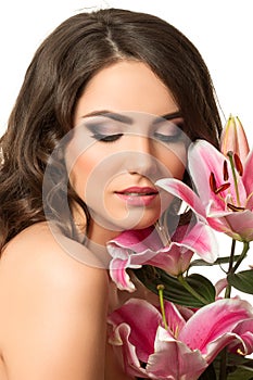 Beauty portrait of young brunette woman near pink lily