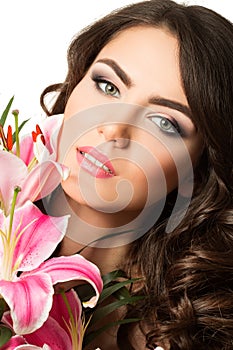 Beauty portrait of young brunette woman near pink lily