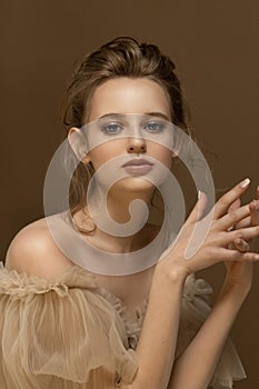 Beauty portrait of young caucasian model with bare shoulders. Trendy fashion studio shot in beige tones.