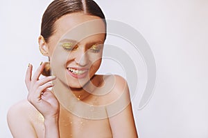 Beauty portrait of young elegant girl. White background, studio shot. Beautiful brunette woman with gold lips and golden