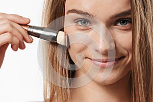Beauty portrait of young half-naked woman applying makeup with brush