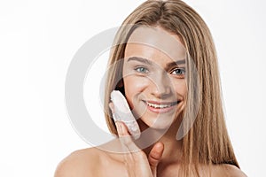 Beauty portrait of young half-naked woman applying makeup with sponge