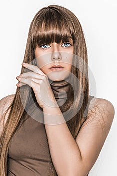 Beauty portrait of young natural model with perfect long healthy shiny hairstyle isolated on white posing in studio. Brunette girl