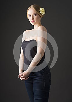 Beauty portrait of a young plus size blonde with yellow rose in her hair