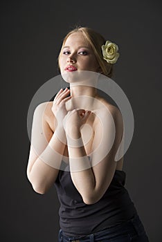 Beauty portrait of a young plus size blonde with yellow rose in her hair