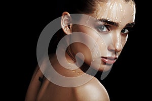 Beauty Portrait of Young Woman with Strobing Makeup Liquid on Fa