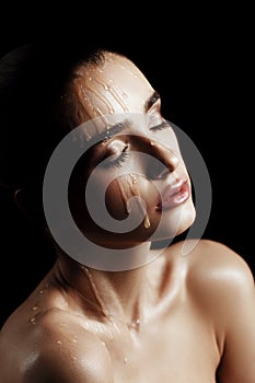 Beauty Portrait of Young Woman with Strobing Makeup Liquid on Fa