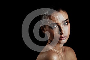 Beauty Portrait of Young Woman with Strobing Makeup Liquid on Fa