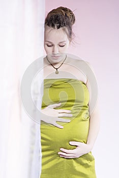 Beauty pregnant woman behind curtain