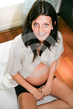 beauty pregnant woman sit on bed in home waiting expecting baby