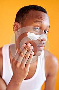 Beauty procedure and skin care, young manful man with face mask on around nose zone photo