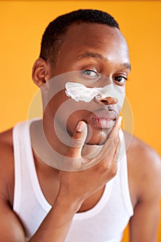 Beauty procedure and skin care, young manful man with face mask on around nose zone photo