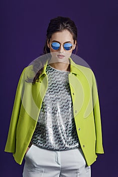 Beauty profile portrait of a fashion model in sunglasses, young woman in a trend clothes, isolated purple background.