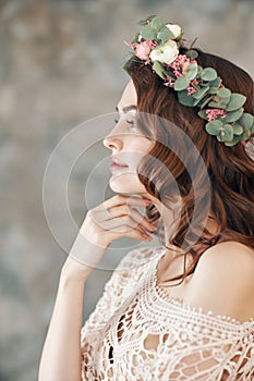 Beauty profile portrait of young woman with wreath of flowers in her hair