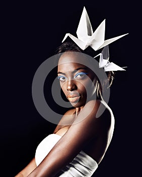 Beauty radiating no matter the circumstance. Portrait of a beautiful ethnic woman posing with origami birds on her head.