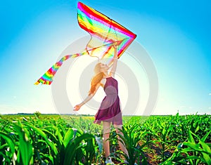 Beauty redhead girl with flying colorful kite