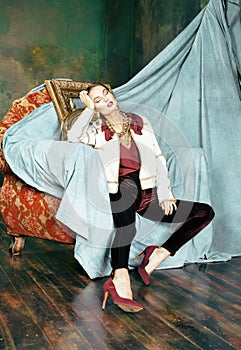 Beauty rich brunette woman in luxury interior near empty frames, fashion make up vintage background