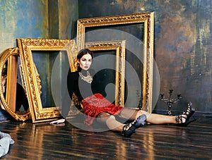 Beauty rich brunette woman in luxury interior near empty frames, vintage elegance