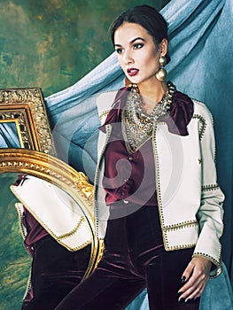 Beauty rich brunette woman in luxury interior near empty frames, vintage elegance brunette