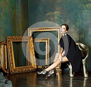 beauty rich brunette woman in luxury interior near empty frames, wearing fashion clothes, lifestyle pretty real people