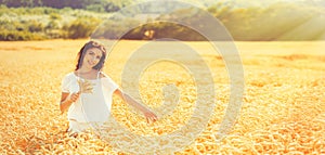 Beauty romantic girl enjoying nature in outdoors. Happy young woman in white shorts on the field of golden ripe wheat